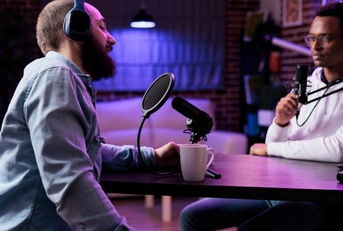 Two podcasters in a semi-dark room