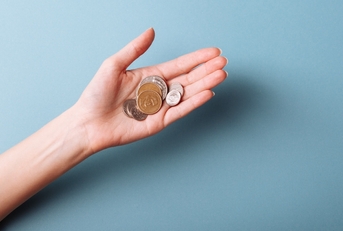 womans hand holding a heap of coins