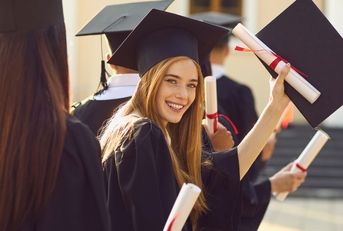smiling college graduate standing with diploma