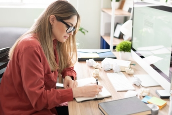 female author sitting in front of computer to write stories