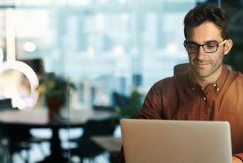 businessman wearing glasses using laptop at work
