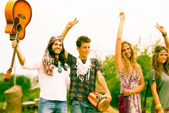 hippie friends standing on road in countryside holding drums and instruments