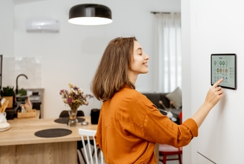 young woman controlling home with a digital touch screen panel