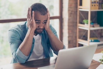 Man frustrated looking at computer