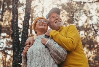 middle age cheerful people smiling and looking at the the trees 