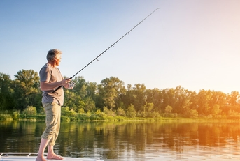 senior man standing on boat fishing