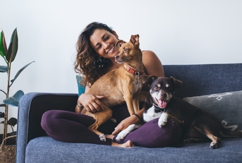 fit woman having fun with adorable mongrel dogs