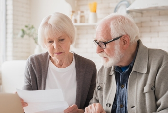 snior laptop sitting at table reviewing loans 
