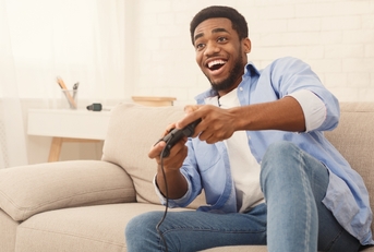young man playing video games at home