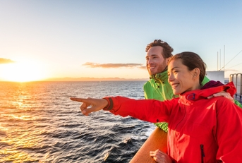 cruise travel tourists couple pointing at sea view from ferry tour