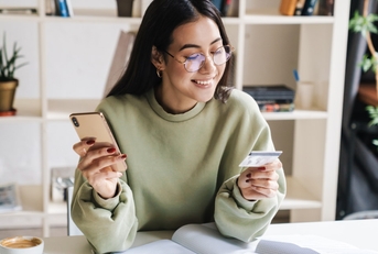 happy woman holding card and smartphone in hands