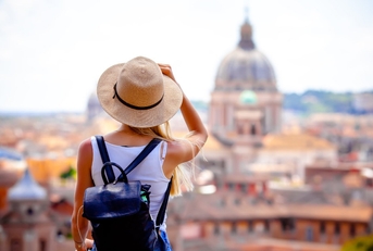 female tourist wearing black backpack and sunny hat exploring rome while on vacation