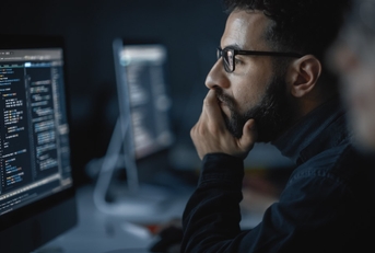 man coding on computer late at night