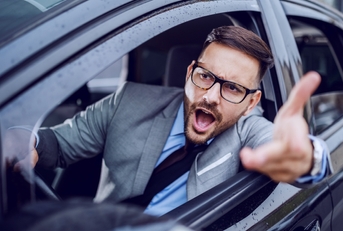 Man leaning out of car window yelling