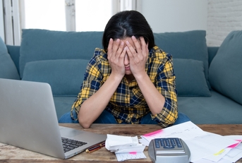 Stressed woman will bills and computer