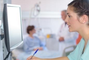 female medical assistant using pen to write on form 