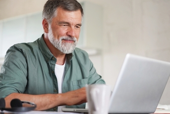 mature man in casual suit sitting at the table 