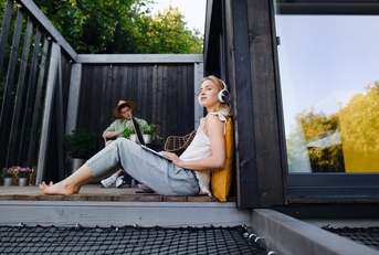 young couple with laptop resting outdoors in a tiny house