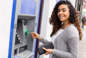 Smiling woman using an ATM