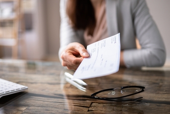 businessperson's hand holding cheque