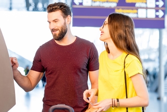 Couple withdrawing money from an ATM at an airport