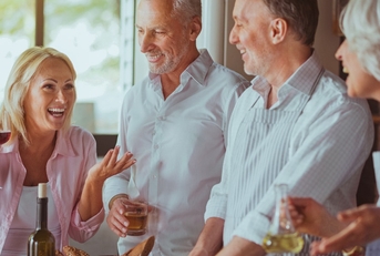 happy and relaxed couple are talking and enjoying drinks before starting dinner.