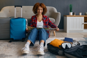 woman reading travel map surrounded with luggage