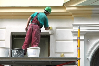 man painting house from outside.