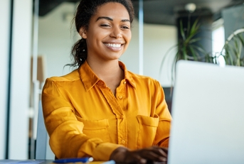 Smiling woman typing on a computer