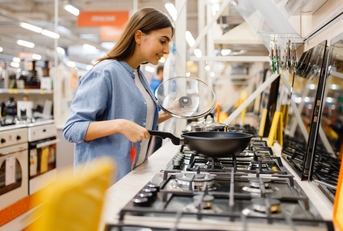 Young woman choosing gas stove