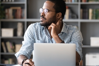 sitting at work desk with laptop