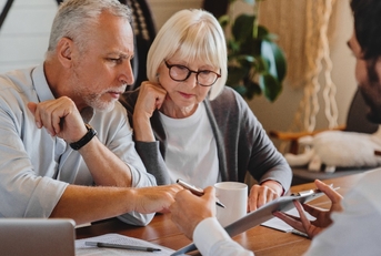 Advisor explaining paperwork to a retired elderly couple.