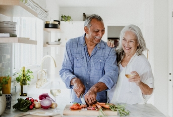 senior couple is preparing a meal together.