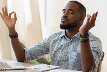 african guy meditating while remote working