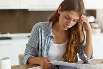 stressed woman reviewing bills at home