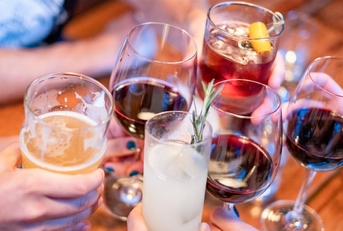 people toasting with drinks at restaurant