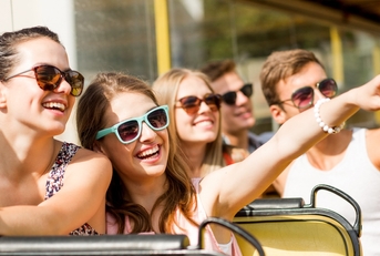 smiling friends traveling by tour bus