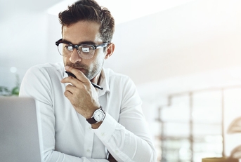 Man using laptop seeking a solution to a problem.