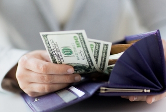 Close up of woman hands with wallet and money.