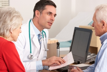 male doctor talking to senior couple