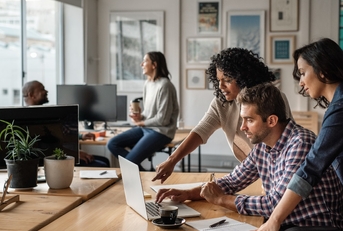 three colleagues using laptop together