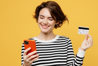 Smiling woman holding a phone and credit card