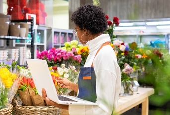african american female florist inspecting flowers