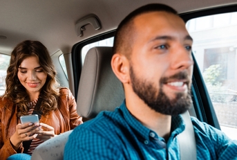 Smiling man driving woman