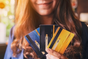 Smiling woman holding three credit cards