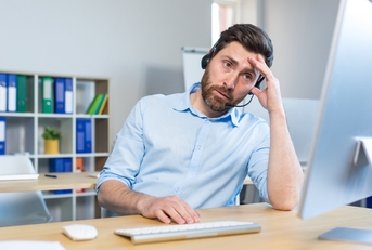 tired man working at a computer