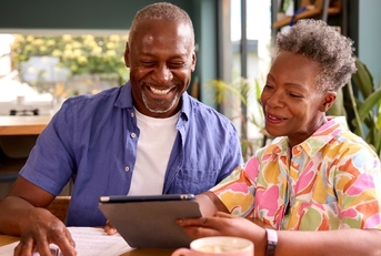 senior couple reviewing bills using tablet