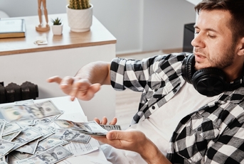 man counts dollar banknotes