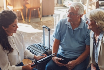 senior couple consulting female travel agent