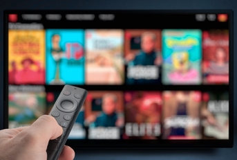 man streaming tv programs using remote
